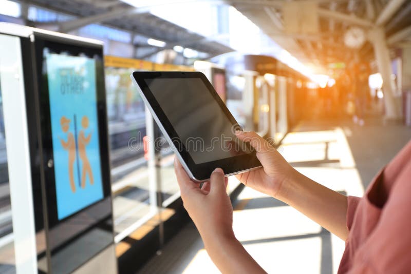 Femme à l'aide du comprimé numérique sur le train de ciel de BTS à l'arrière-plan de Bangkok, Thaïlande, concept de technologie d photo stock Femme à l'aide du comprimé numérique sur le train de ciel de BTS à l'arrière-plan de Bangkok, Thaïlande, concept de technologie d photo stock