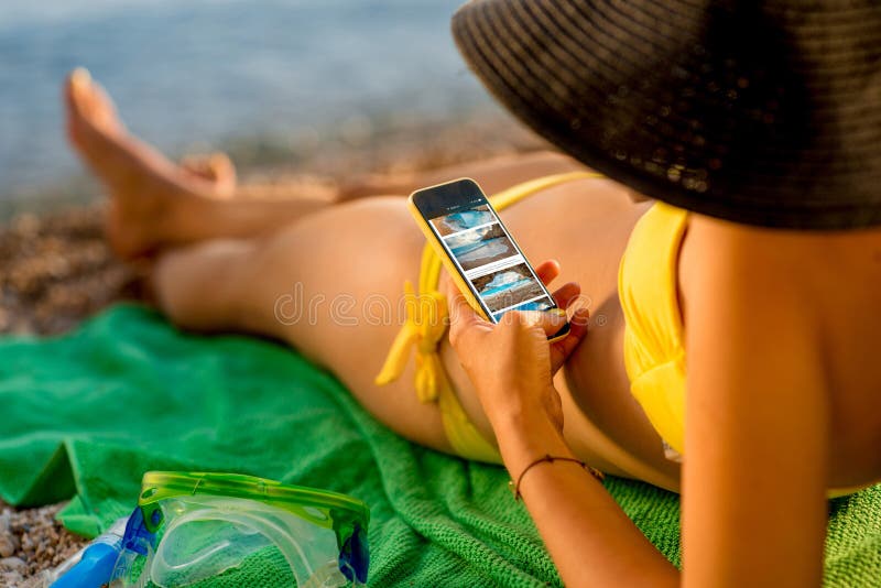 Femme à l'aide du téléphone portable sur la plage photo stock Femme à l'aide du téléphone portable sur la plage photo stock