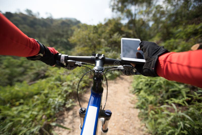 Femme à l'aide du téléphone portable tout en montant le vélo image stock Femme à l'aide du téléphone portable tout en montant le vélo image stock