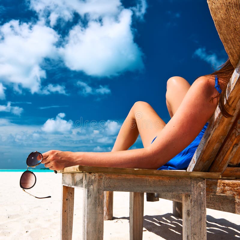 Femme à la plage tenant des lunettes de soleil photos libres de droits Femme à la plage tenant des lunettes de soleil photos libres de droits