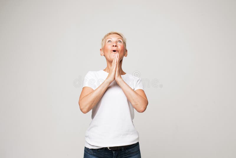 Femme âgée caucasienne avec cheveux courts isolés sur fond de studio gris se sentir surpris par l'accord ou la promotion. images libres de droits