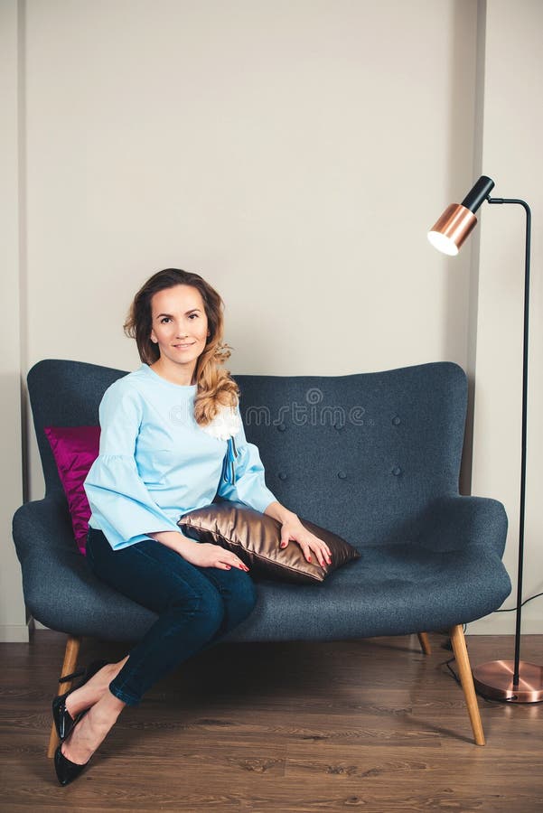 Femme élégant Femme réussie d'affaires s'asseyant sur le sofa élégant Jeune entrepreneur féminin de sourire au bureau moderne La photo libre de droits Femme élégant Femme réussie d'affaires s'asseyant sur le sofa élégant Jeune entrepreneur féminin de sourire au bureau moderne La photo libre de droits