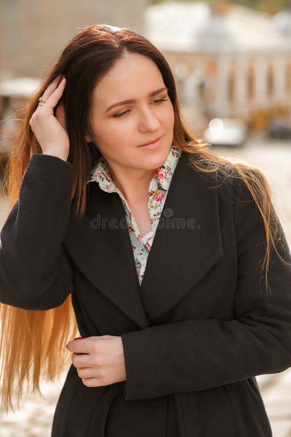 Femme élégante de brune avec de longs cheveux portant le manteau bleu à la mode a image stock Femme élégante de brune avec de longs cheveux portant le manteau bleu à la mode a image stock