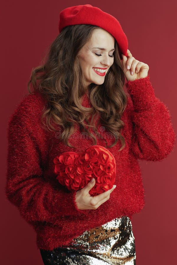 Femme élégante heureuse en chandail rouge et béret avec coeur rouge photographie stock