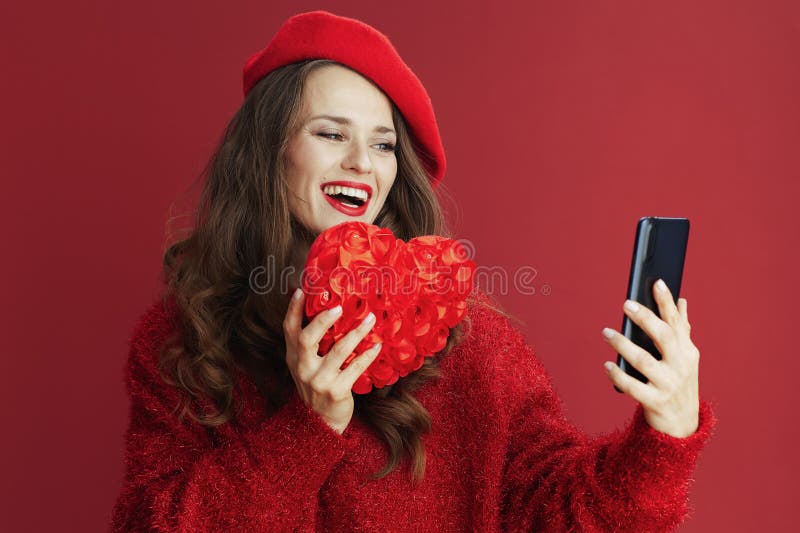 Femme élégante souriante en pull et béret avec chat vidéo photographie stock libre de droits