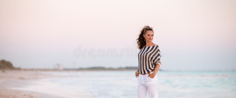 Femme élégante sur la plage dans la soirée photographie stock libre de droits Femme élégante sur la plage dans la soirée photographie stock libre de droits