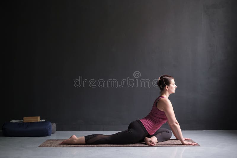 Femme établissant faisant la variation facile de l'un Roi à jambes Pigeon Pose image libre de droits Femme établissant faisant la variation facile de l'un Roi à jambes Pigeon Pose image libre de droits