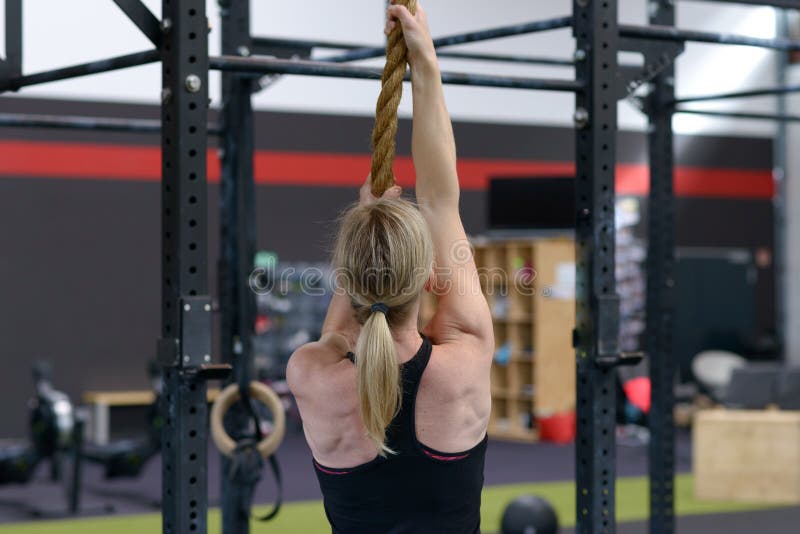 Femme établissant sur une corde dans un gymnase images libres de droits Femme établissant sur une corde dans un gymnase images libres de droits