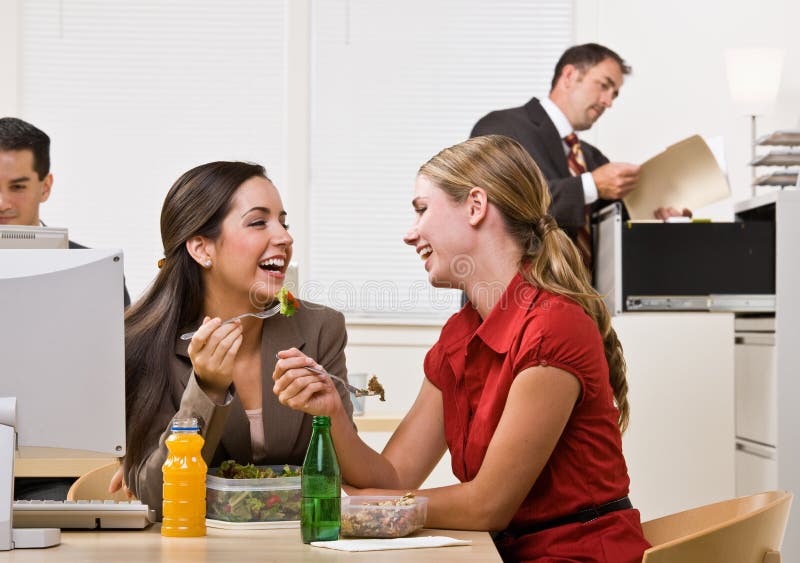 Femmes d'affaires mangeant de la salade pour le déjeuner image stock Femmes d'affaires mangeant de la salade pour le déjeuner image stock