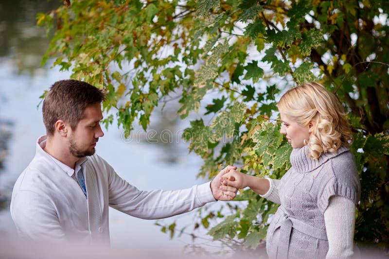 Femmes enceintes heureuses et son mari pendant la promenade avec un homme près du lac images libres de droits Femmes enceintes heureuses et son mari pendant la promenade avec un homme près du lac images libres de droits