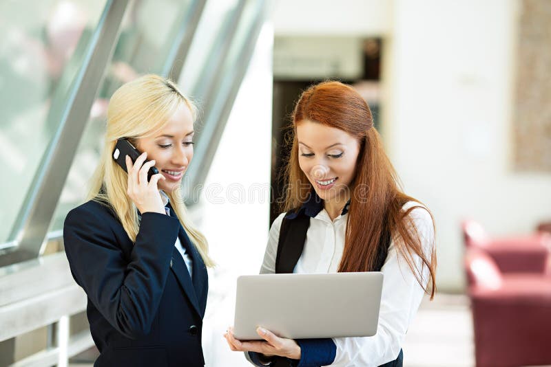 Femmes enthousiastes et surpirsed d'affaires recevant de bonnes actualités par l'intermédiaire de l'email photo stock Femmes enthousiastes et surpirsed d'affaires recevant de bonnes actualités par l'intermédiaire de l'email photo stock