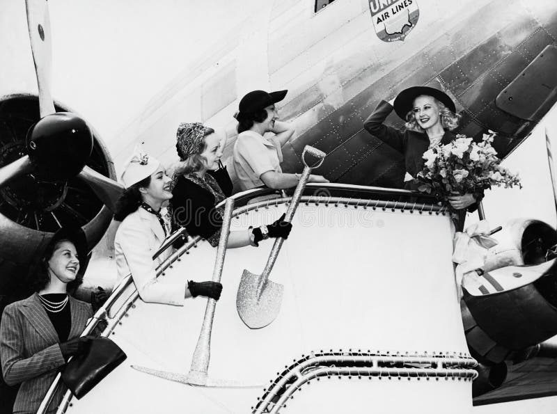 Women sending off friend boarding plane (All persons depicted are no longer living and no estate exists. Supplier grants that there will be no model release issues.). Women sending off friend boarding plane (All persons depicted are no longer living and no estate exists. Supplier grants that there will be no model release issues.)