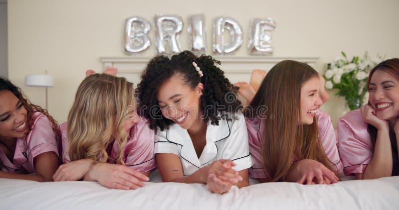 Femmes et rire au lit pour la fête de la douche nuptiale et les liens dans la chambre d'hôtel. amis heureux de groupe banque de vidéos