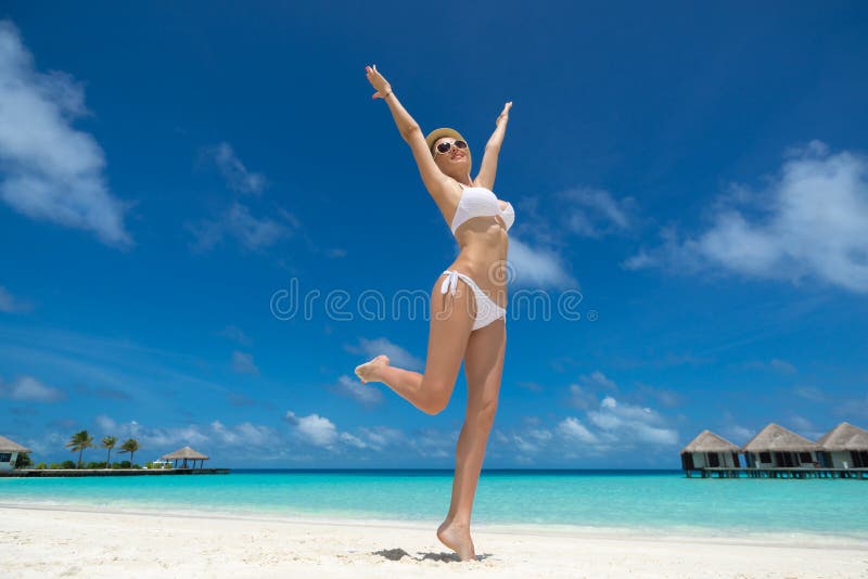 Femmes heureuses dans le bikini sur la plage tropicale photographie stock libre de droits Femmes heureuses dans le bikini sur la plage tropicale photographie stock libre de droits