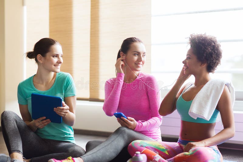 Femmes heureuses écoutant la musique dans le gymnase photos stock Femmes heureuses écoutant la musique dans le gymnase photos stock