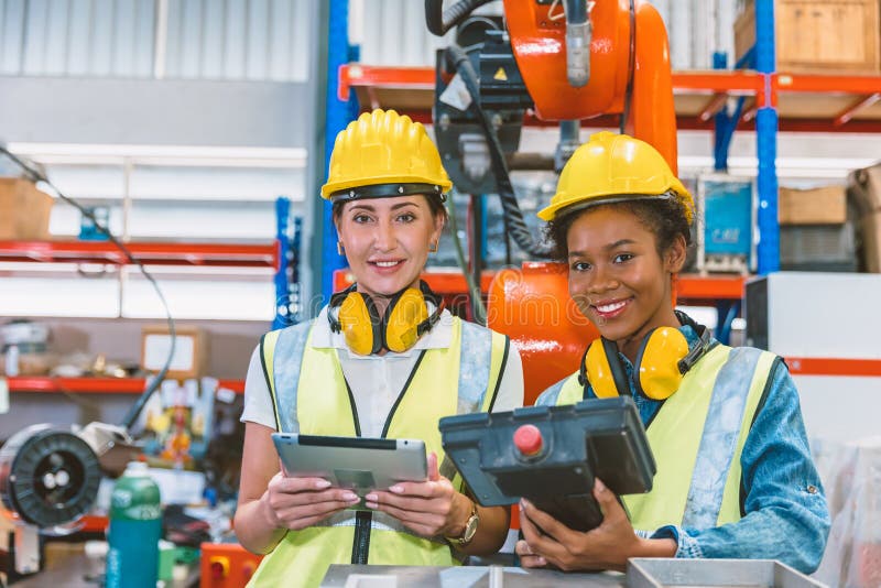 Femmes ingénieur travail d'équipe formation ensemble au travail dans la machine à souder robotique avancée moderne usine photographie stock libre de droits