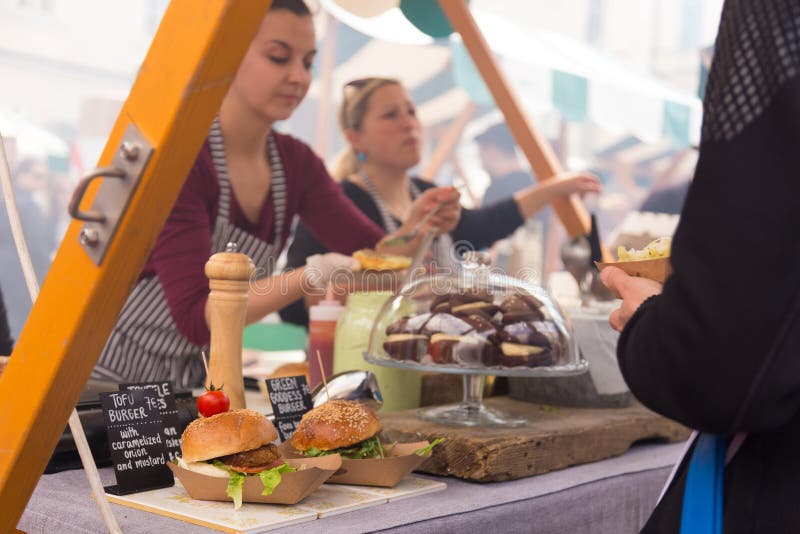 Femmes servant des hamburgers sur le festival de nourriture à Ljubljana, Slovénie photographie stock libre de droits Femmes servant des hamburgers sur le festival de nourriture à Ljubljana, Slovénie photographie stock libre de droits