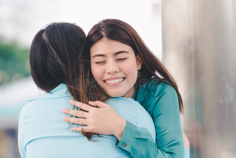 Portrait of happy asian women hugging each friend outdoor city background. Portrait of happy asian women hugging each friend outdoor city background