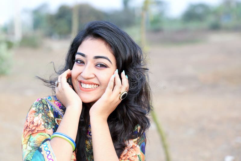 Femmina che posa le mani felici di sorriso sul fronte fotografie stock Femmina che posa le mani felici di sorriso sul fronte fotografie stock