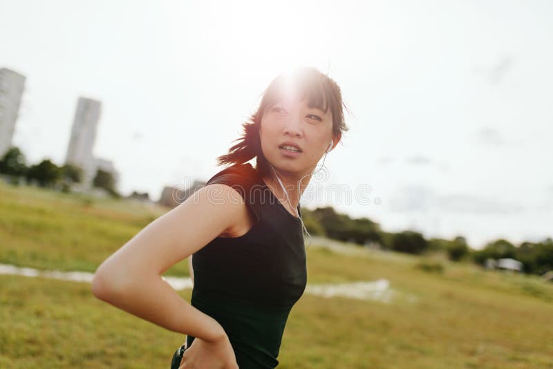 Femmina di forma fisica sul campo che dà un'occhiata indietro immagine stock Femmina di forma fisica sul campo che dà un'occhiata indietro immagine stock