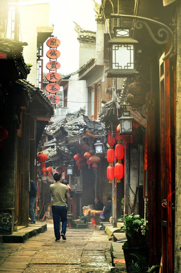 Fenghuang, China - 15 de maio de 2017: Homem com as crianças que andam em torno da rua na cidade de Phoenix Fenghuang fotografia de stock Fenghuang, China - 15 de maio de 2017: Homem com as crianças que andam em torno da rua na cidade de Phoenix Fenghuang fotografia de stock