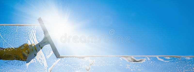 Fensterputzerreinigungsfenster mit Gummiwalze und Wischer an einem sonnigen Tag mit einem hellen blauen Himmel