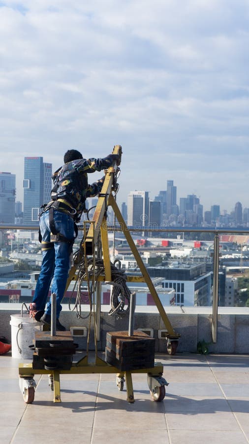 Fensterreinigungsangestellter mit Arbeitswerkzeugen und Stadthintergrund lizenzfreies stockfoto Fensterreinigungsangestellter mit Arbeitswerkzeugen und Stadthintergrund lizenzfreies stockfoto