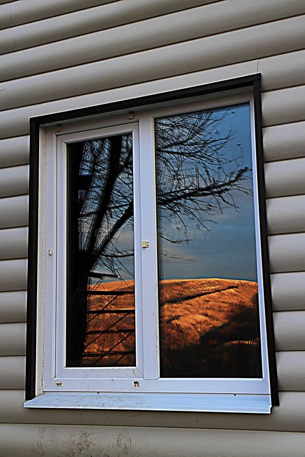 fenêtre avec la réflexion du beau paysage de la maison de steppe engainé par le dégrossissage photos stock fenêtre avec la réflexion du beau paysage de la maison de steppe engainé par le dégrossissage photos stock
