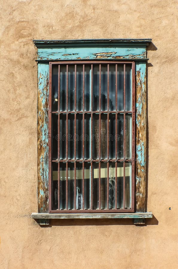 Fenêtre barrée sale sur le mur de stuc avec la peinture de turquoise d'épluchage images stock Fenêtre barrée sale sur le mur de stuc avec la peinture de turquoise d'épluchage images stock
