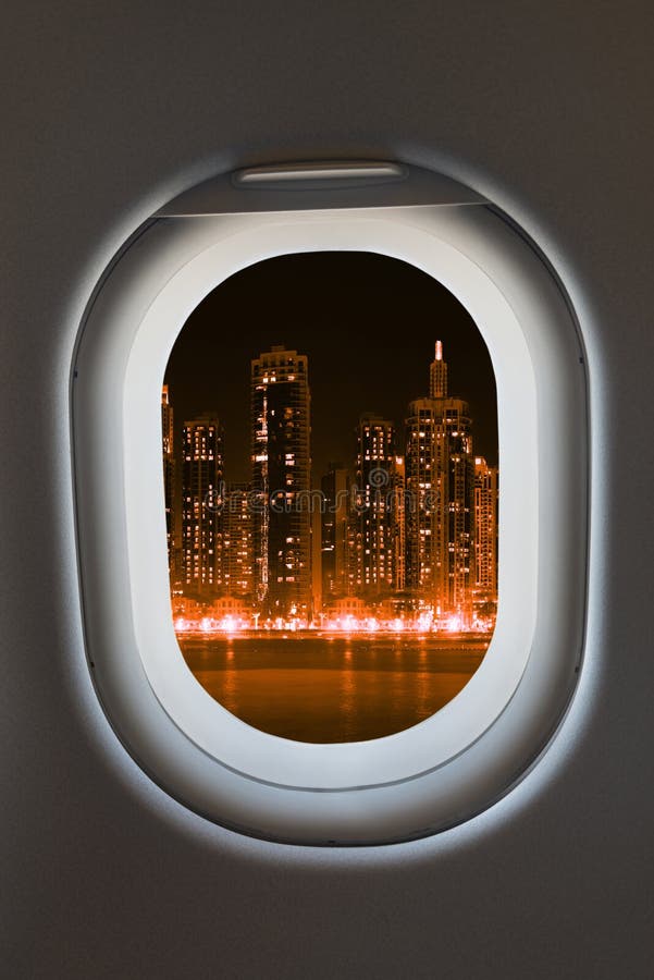 Airplane window from interior of aircraft with modern megalopolis city view at night. Airplane window from interior of aircraft with modern megalopolis city view at night.