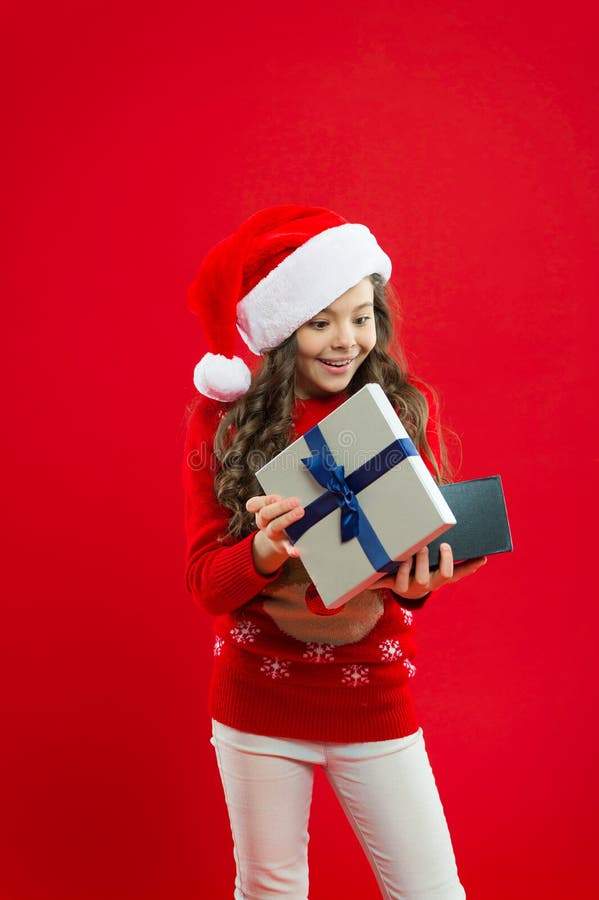 Feriados de inverno felizes Menina pequena Criança da menina no chapéu vermelho de Santa Presente para o Xmas Infância Compra do fotos de stock Feriados de inverno felizes Menina pequena Criança da menina no chapéu vermelho de Santa Presente para o Xmas Infância Compra do fotos de stock