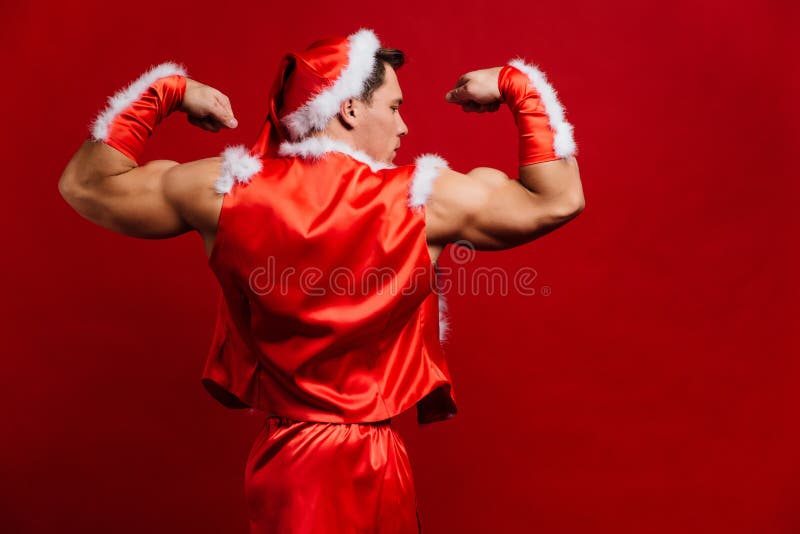 Feriados do Natal chapéu vestindo forte 'sexy' de Papai Noel Homem muscular novo Fundo vermelho imagens de stock royalty free Feriados do Natal chapéu vestindo forte 'sexy' de Papai Noel Homem muscular novo Fundo vermelho imagens de stock royalty free