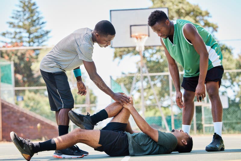 Criança de lesão no joelho de basquete com o pai colocou band-aid