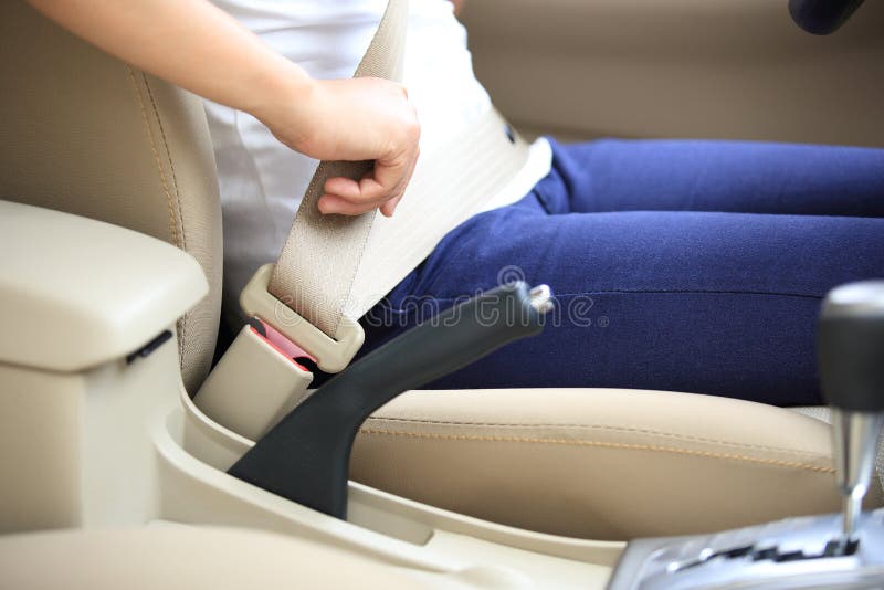 Fermaglio dell'autista della donna sulla cintura di sicurezza in automobile
