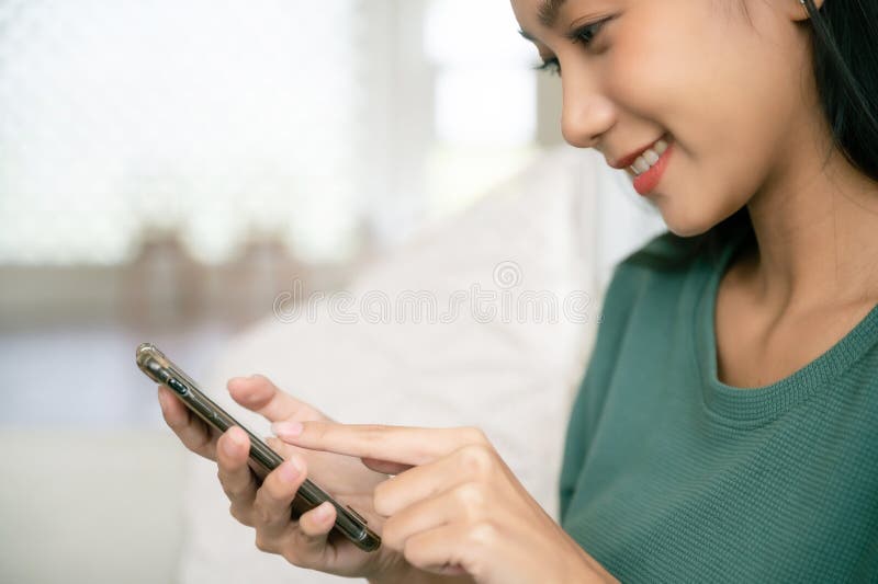Fermer l'image joyeuse jeune asiatique femme relaxante à la maison elle assise sur un canapé images stock