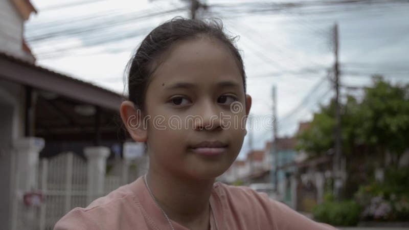 Fermer le portrait d'une jolie fille asiatique à vélo sourit au village banque de vidéos