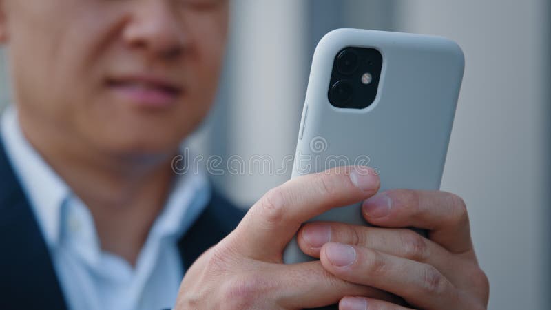 Fermer les mains masculines d'un homme d'âge moyen asiatique floue tenant un téléphone cellulaire bavarder des textos dans le chat clips vidéos