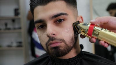 Coiffeur Faisant La Coupe De Cheveux De La Barbe à L'aide D'un Peigne Et De  Ciseaux Pour Un Jeune Homme Séduisant Dans Un Salon De Coiffure Pour Hommes