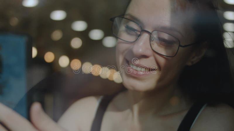 Fermeture d'une femme tenant le téléphone cellulaire dans un caffe. parler à quelqu'un d'aimé sur téléphone portable pendant la pa banque de vidéos