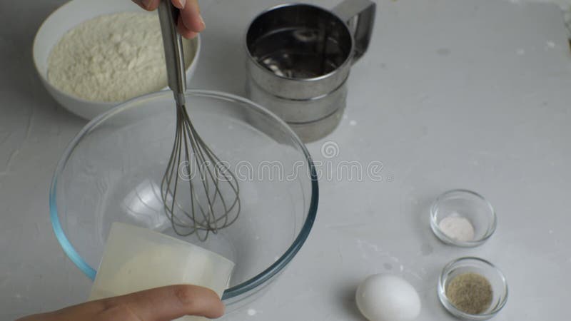 Fermeture d'une main de femmes versant kéfir dans un bol transparent clips vidéos