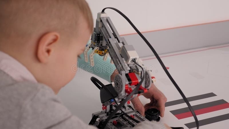 Fermeture du groupe d'enfants jouant avec des robots assemblés à partir de pièces en plastique banque de vidéos