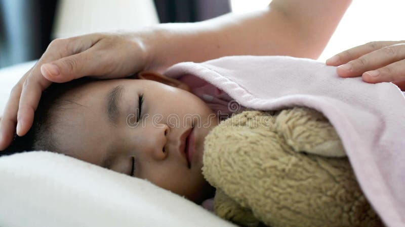 Fermez la mignonne petite fille asiatique Dormir sur le lit, mère Mettre la couverture sur un bébé Vue latérale banque de vidéos