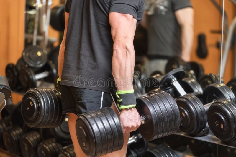 Fermez-vous de l'homme musculaire tenant l'haltère lourde dans le gymnase photos libres de droits Fermez-vous de l'homme musculaire tenant l'haltère lourde dans le gymnase photos libres de droits
