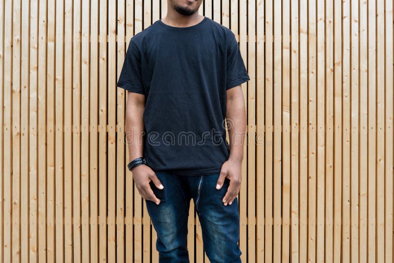 Fermez-vous de l'homme à la peau foncée attirant dans le T-shirt noir sur le fond en bois photo stock Fermez-vous de l'homme à la peau foncée attirant dans le T-shirt noir sur le fond en bois photo stock