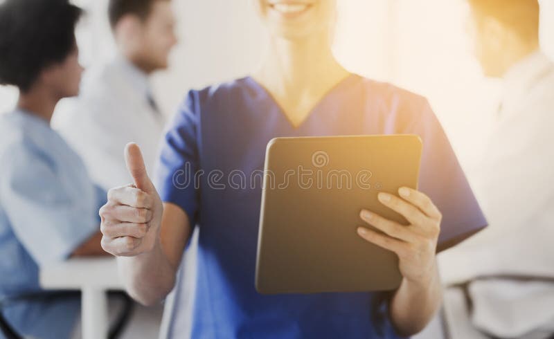 Gros plan d'une infirmière avec une tablette affichant un pouce levé image libre de droits