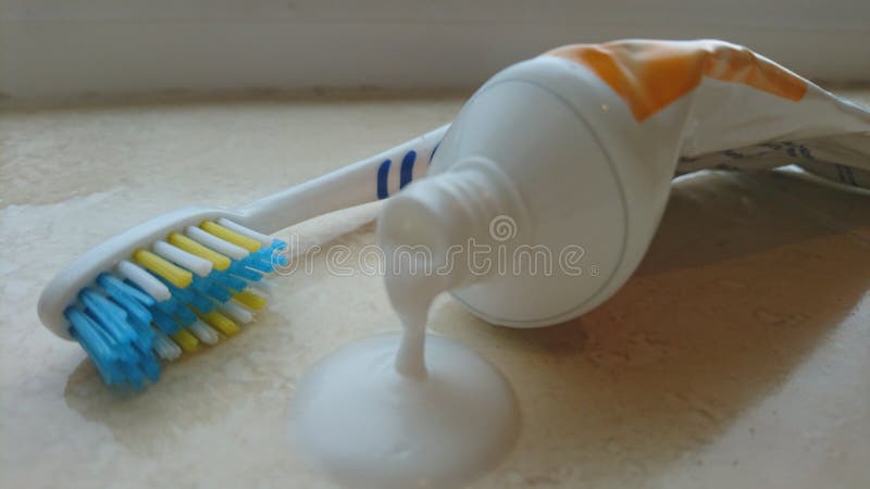 Fermez-vous de l'égoutture de pâte dentifrice hors du tube avec la brosse à dents