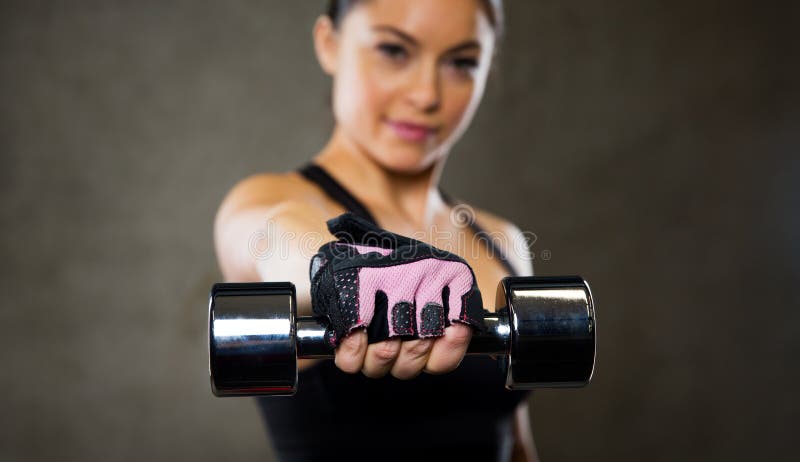 Fermez-vous de la femme tenant l'haltère dans le gymnase photographie stock Fermez-vous de la femme tenant l'haltère dans le gymnase photographie stock