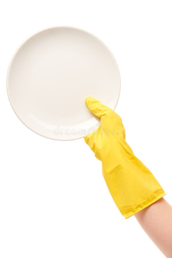 Fermez-vous de la main femelle dans le gant en caoutchouc protecteur jaune tenant le plat blanc propre contre le blanc photos libres de droits Fermez-vous de la main femelle dans le gant en caoutchouc protecteur jaune tenant le plat blanc propre contre le blanc photos libres de droits