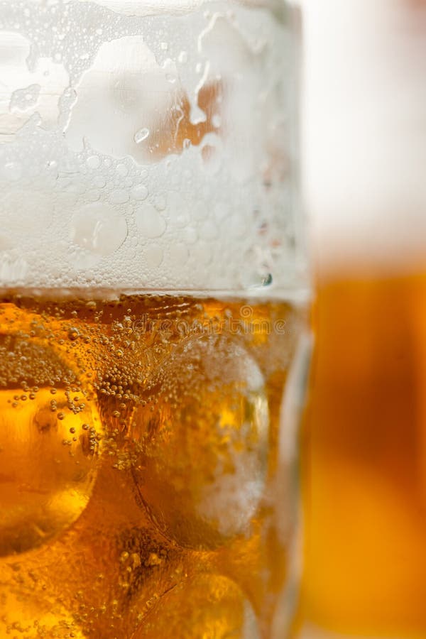 Fermez-vous de la tasse de bière vertial avec la tasse à l'arrière-plan photos libres de droits Fermez-vous de la tasse de bière vertial avec la tasse à l'arrière-plan photos libres de droits