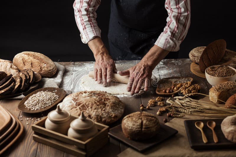 Fermez-vous des mains de boulanger malaxant la p?te et faisant le pain avec une goupille image stock Fermez-vous des mains de boulanger malaxant la p?te et faisant le pain avec une goupille image stock